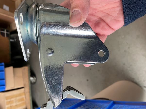 Braked castor housing and pedal shown during assembly inspection