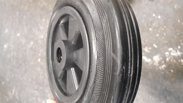 Solid rubber wheel showing cracks along the outer rubber tyre shoulder